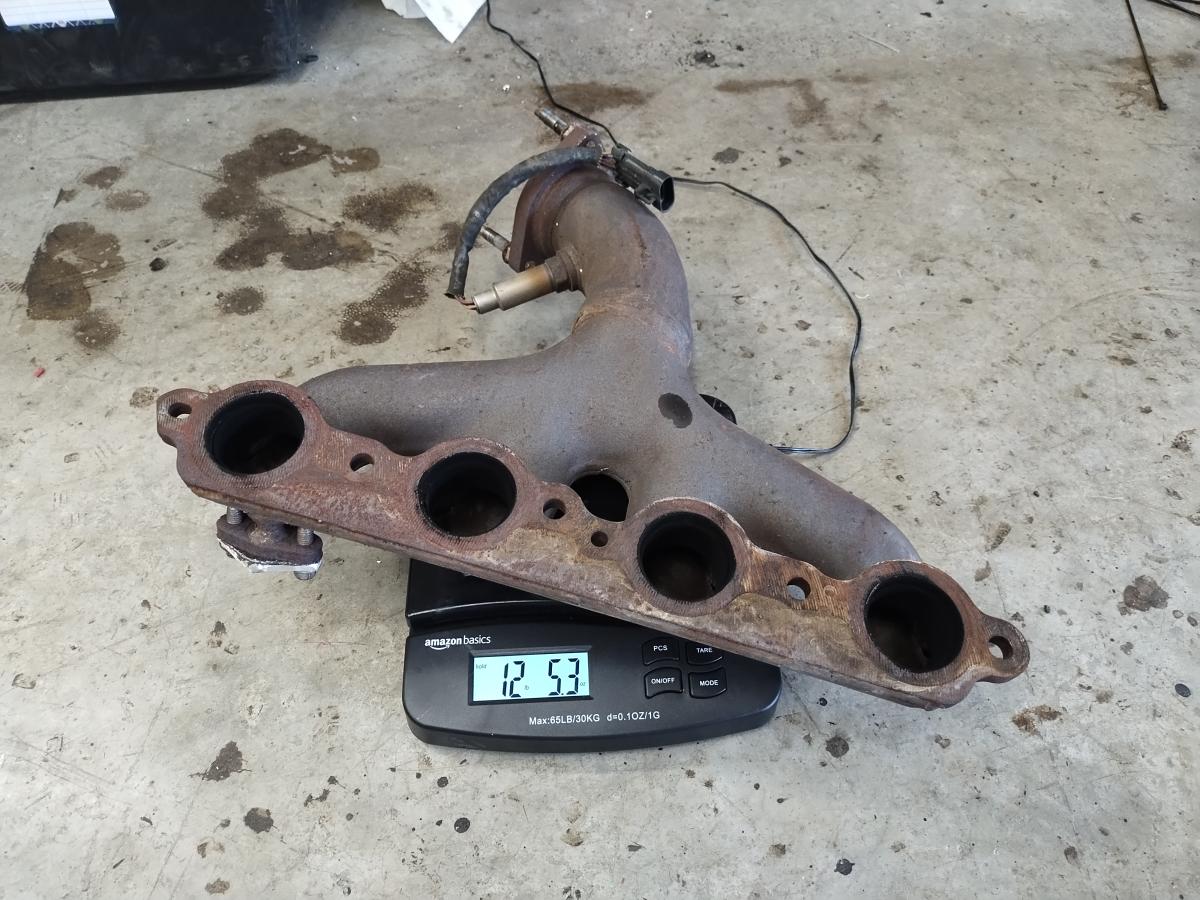 OEM steel headers from a c5 Corvette showing a weight of 12lbs, 5.3oz