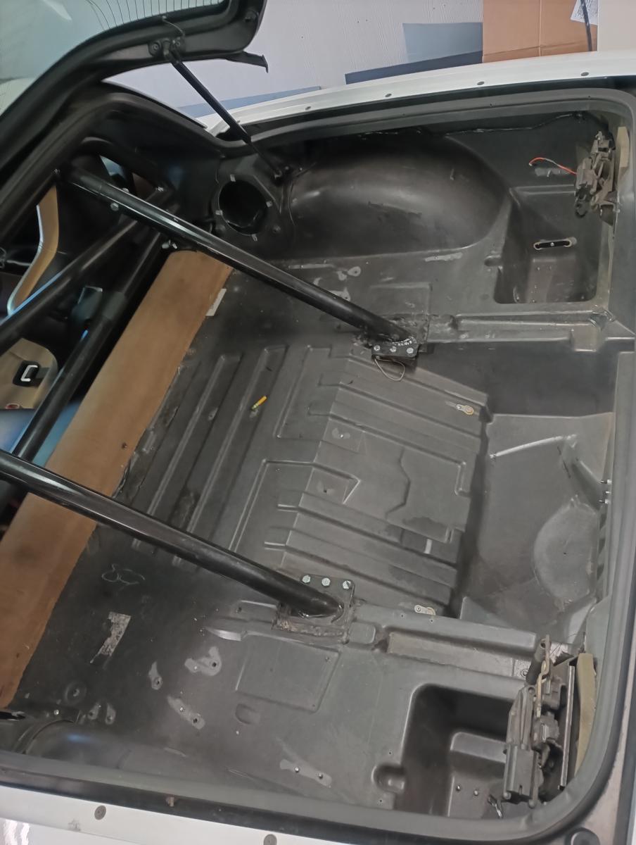 The rear area of a C5 corvette targa top, with all of the carpet and unnecessary brackets removed. An autopower roll bar is in place.