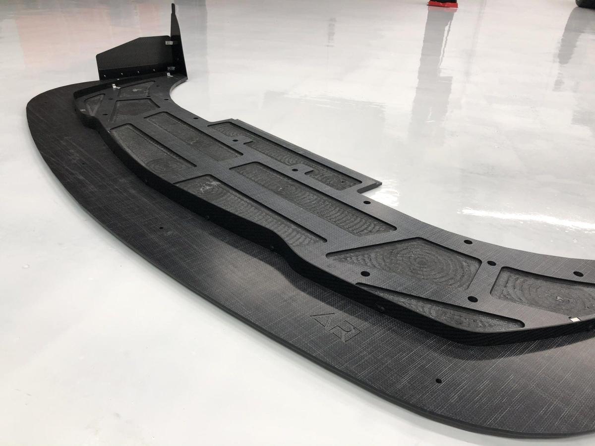 An example picture Jesse found of a splitter with the parts behind the air dam skeletonized (material cut out) to reduce weight.