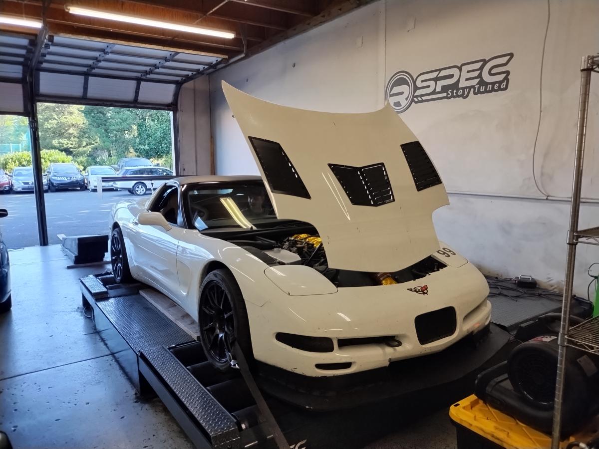 Shred Jesse's white and black C5 Corvette on the dyno at Rspec Tuning. The hood is up with the black trackspec vents showing.