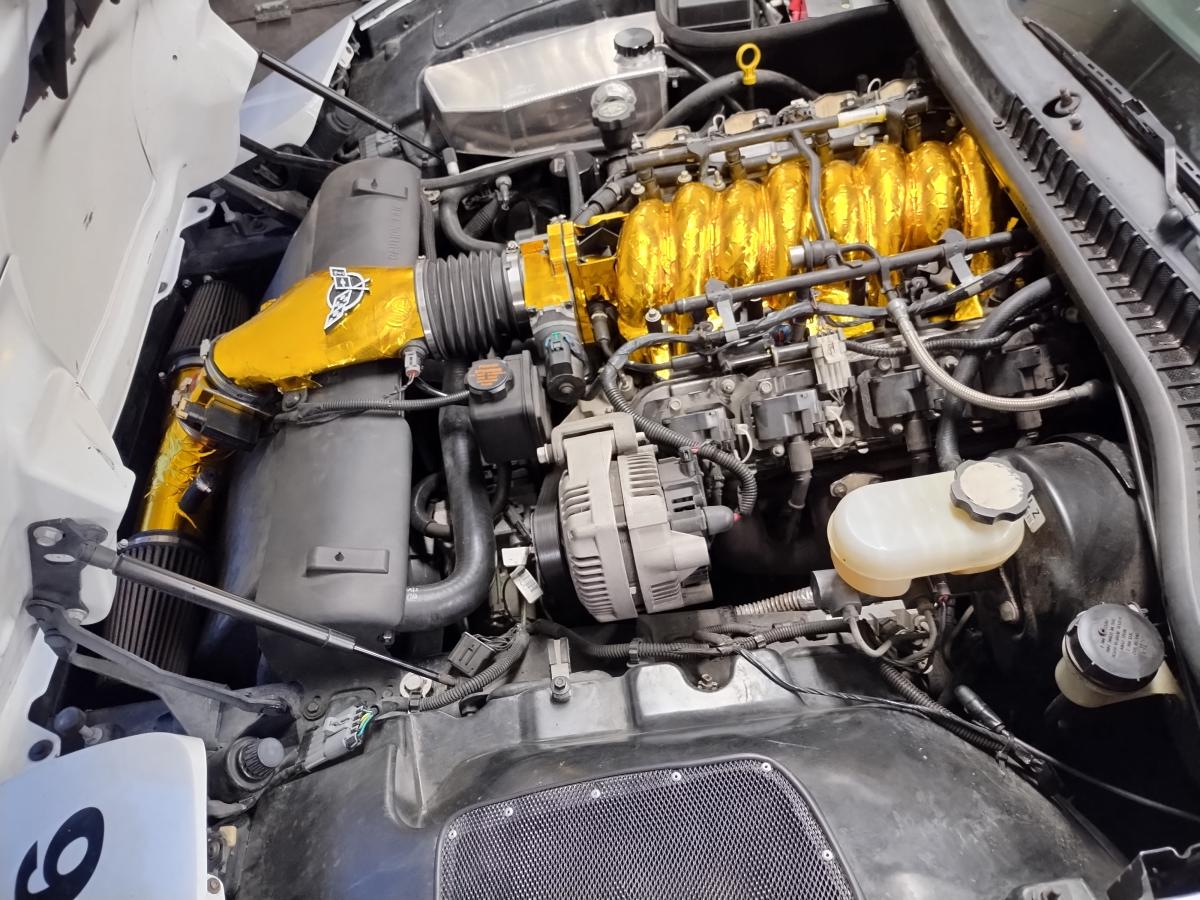 A picture of Shred Jesse's C5 Corvette with LS6 intake on an LS1, with way too much heat reflective tape covering all of the intake and cold air intake