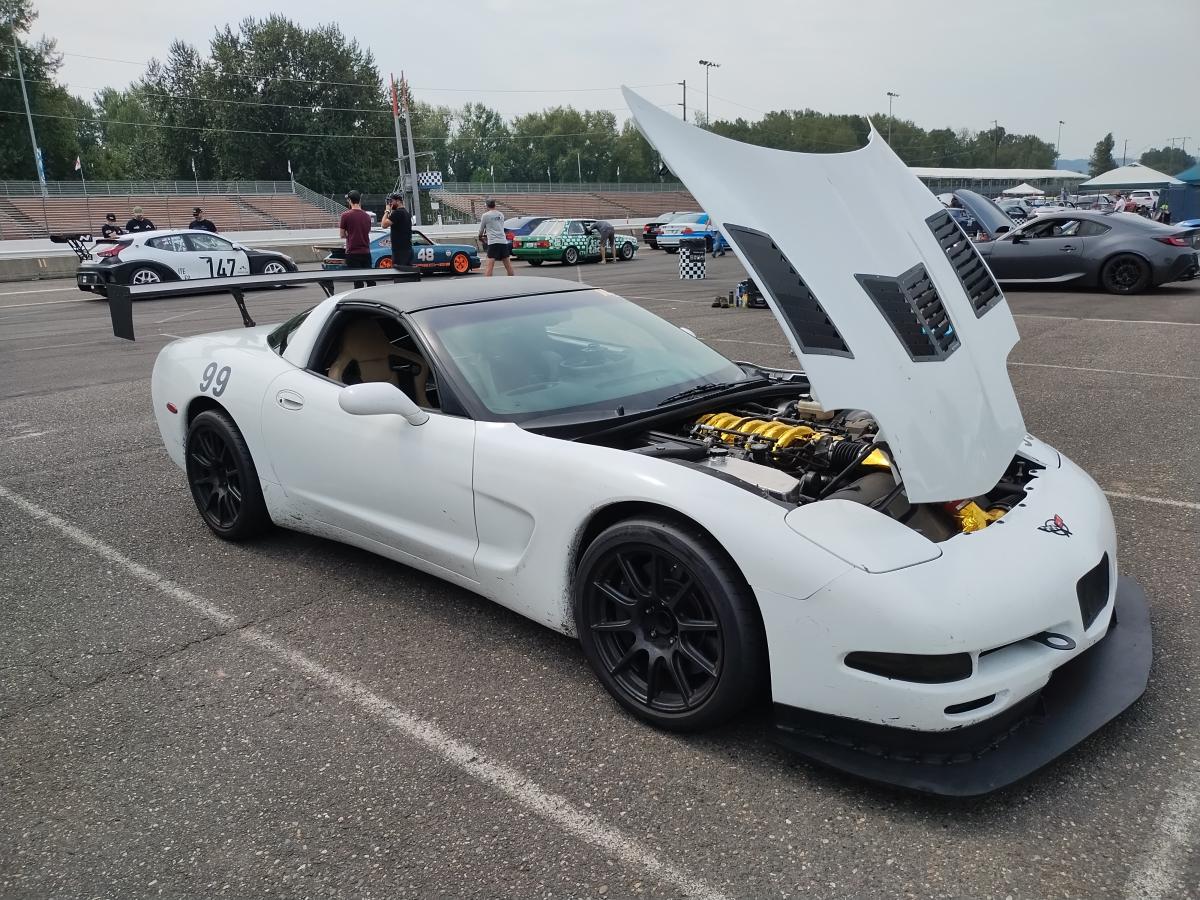 1999 C5 Corvette in the pits at Portland International Raceway with it's hood up and that way too much gold heat tape showing through.